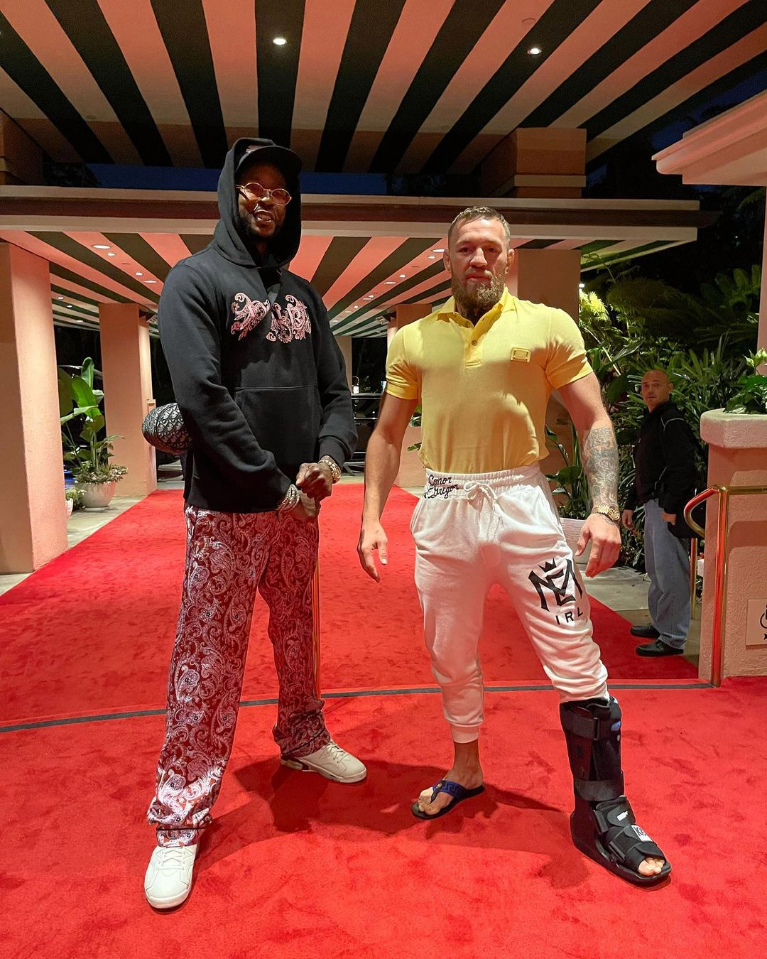 Conor McGregor and 2 Chainz pose with US rapper 2 Chainz, with a surgically-repaired left leg. UFC legend returns to the ring.