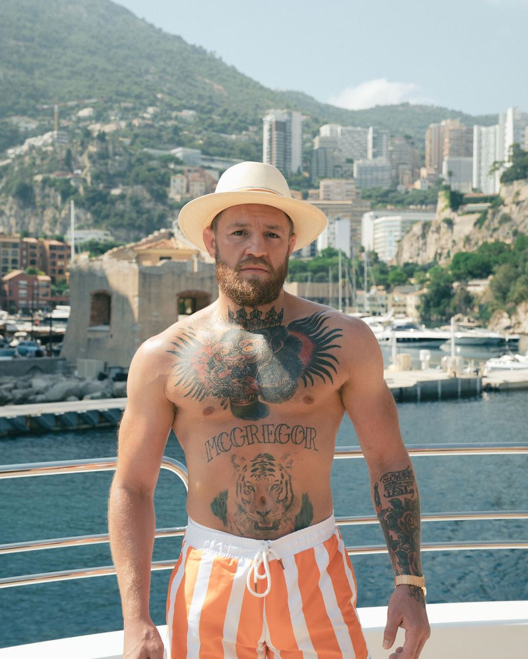 Conor McGregor, UFC fighter, is seated on Conor McGregor's Lamborghini as well as superyachts with pool and floating golf green.