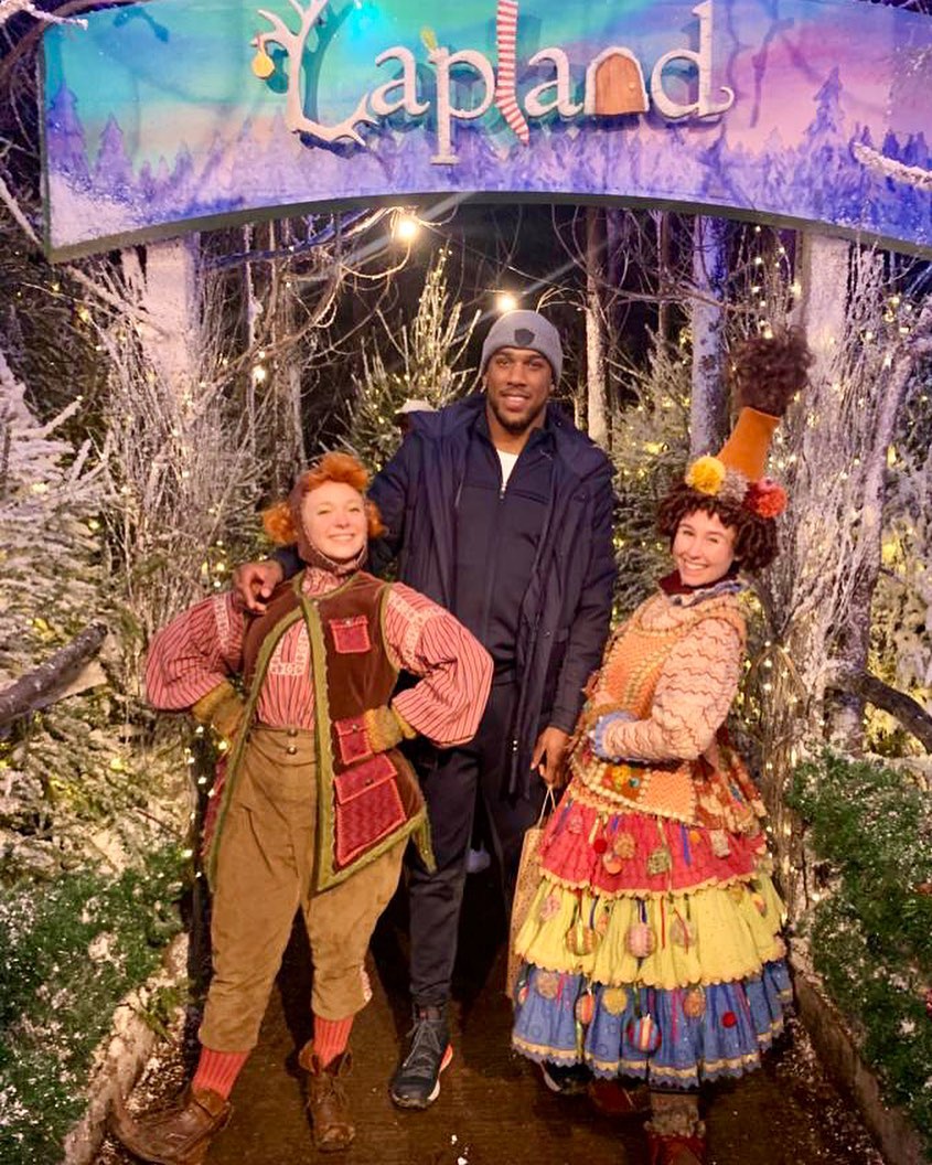 Anthony Joshua struggles to keep his feet on the ice while skating. He holds onto a penguin to prevent him from falling.