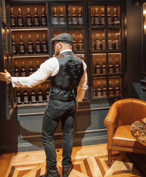 Conor McGregor, UFC legend, reveals his secret stash of Proper 12 whiskey after sustaining a leg injury.