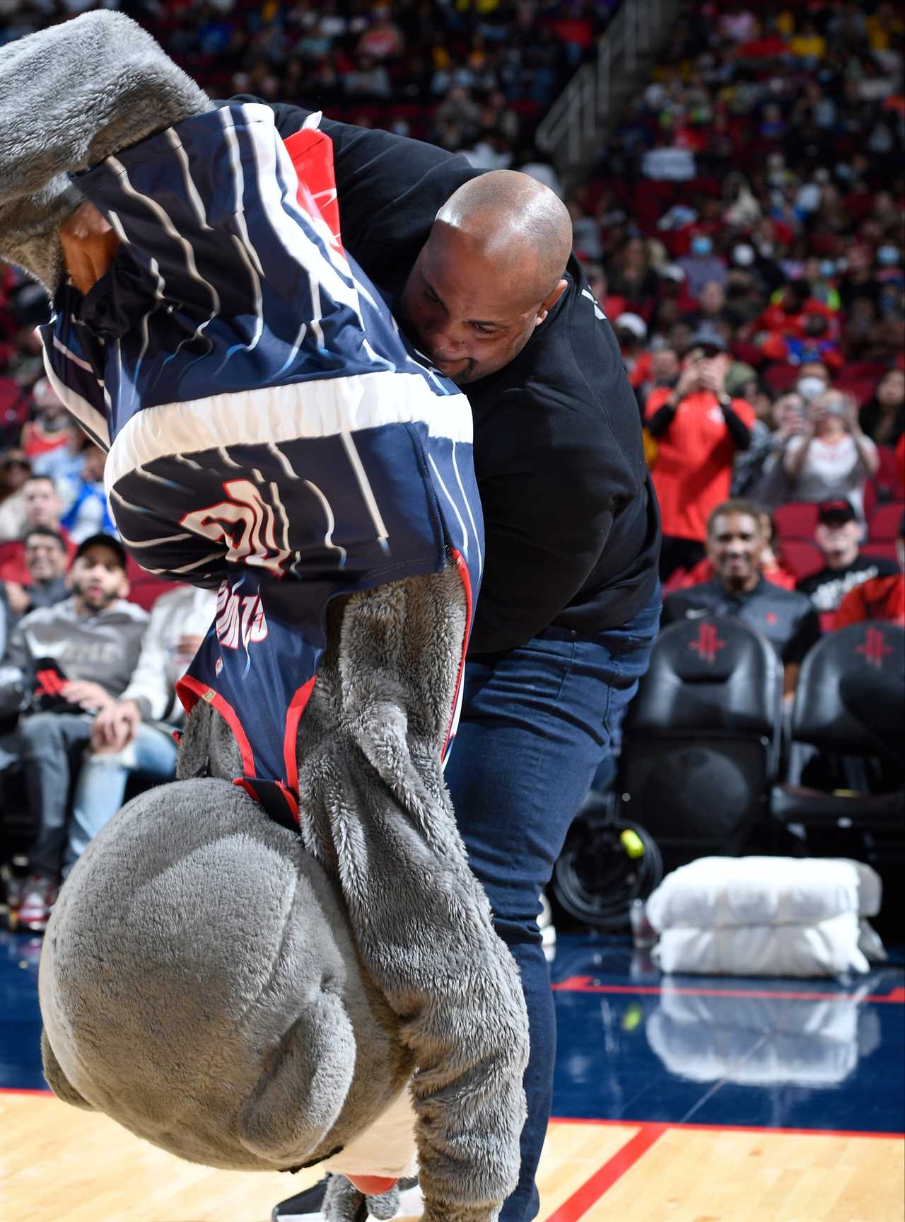 Ex-UFC champion Daniel Cormier (42), proves that he still has it when he takes on Clutch, the Houston Rockets' mascot, at a NBA game
