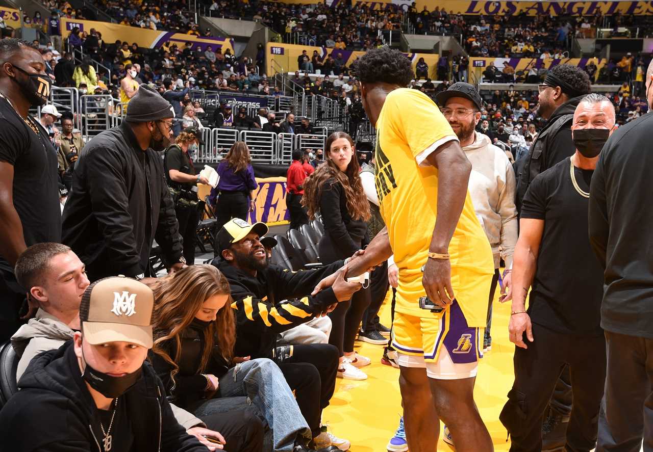 Floyd Mayweather gives $100 bills to children outside the LA Lakers game.