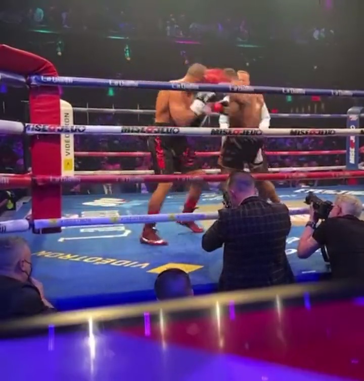 Boxer delivers a sickening punch that knocks opponent off his feet, before sending him backwards onto the canvas.