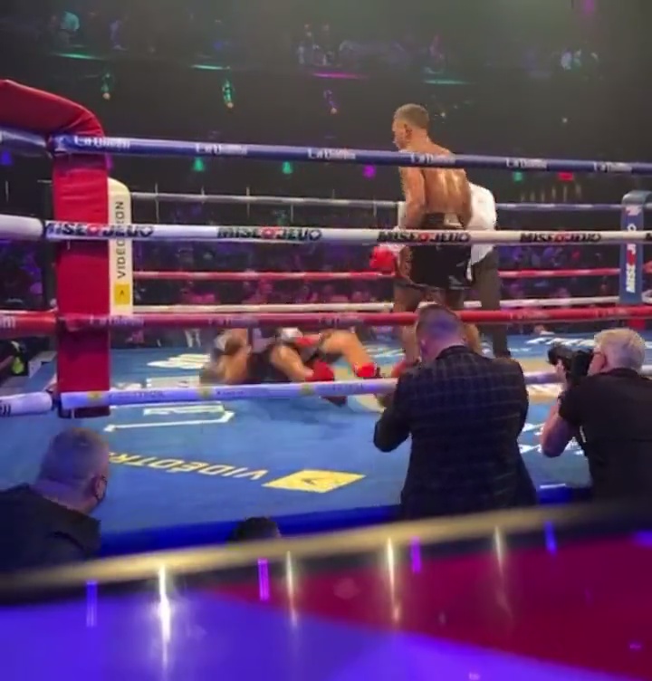 Boxer delivers a sickening punch that knocks opponent off his feet, before sending him backwards onto the canvas.
