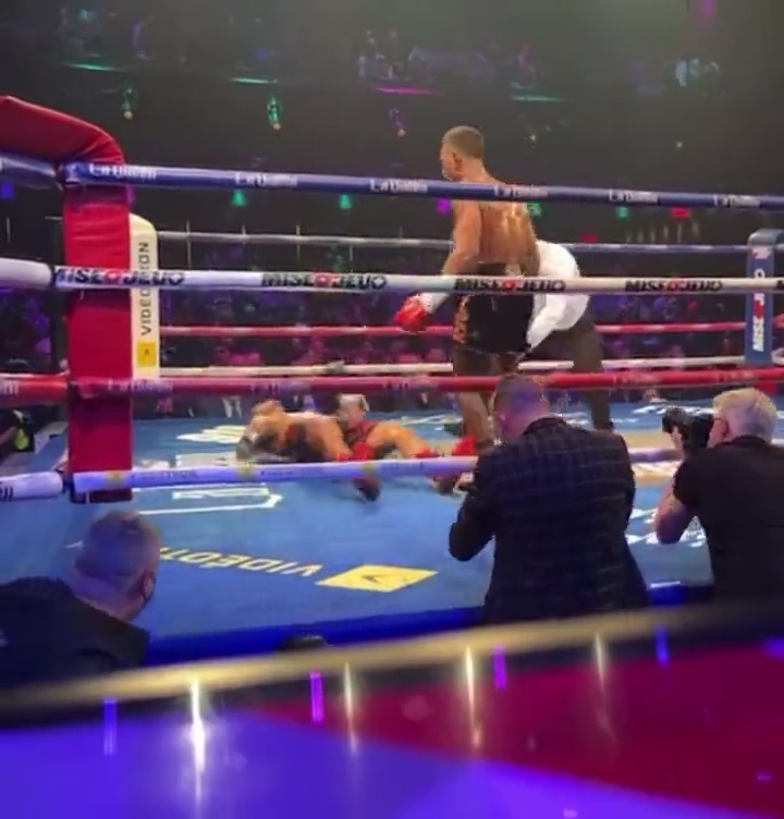 Boxer delivers a sickening punch that knocks opponent off his feet, before sending him backwards onto the canvas.