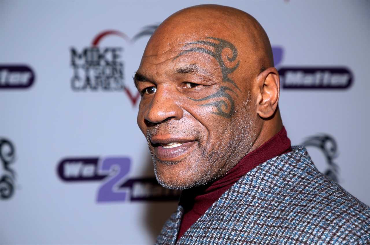 Mike Tyson laughs in the airport lounge after beating a fan.