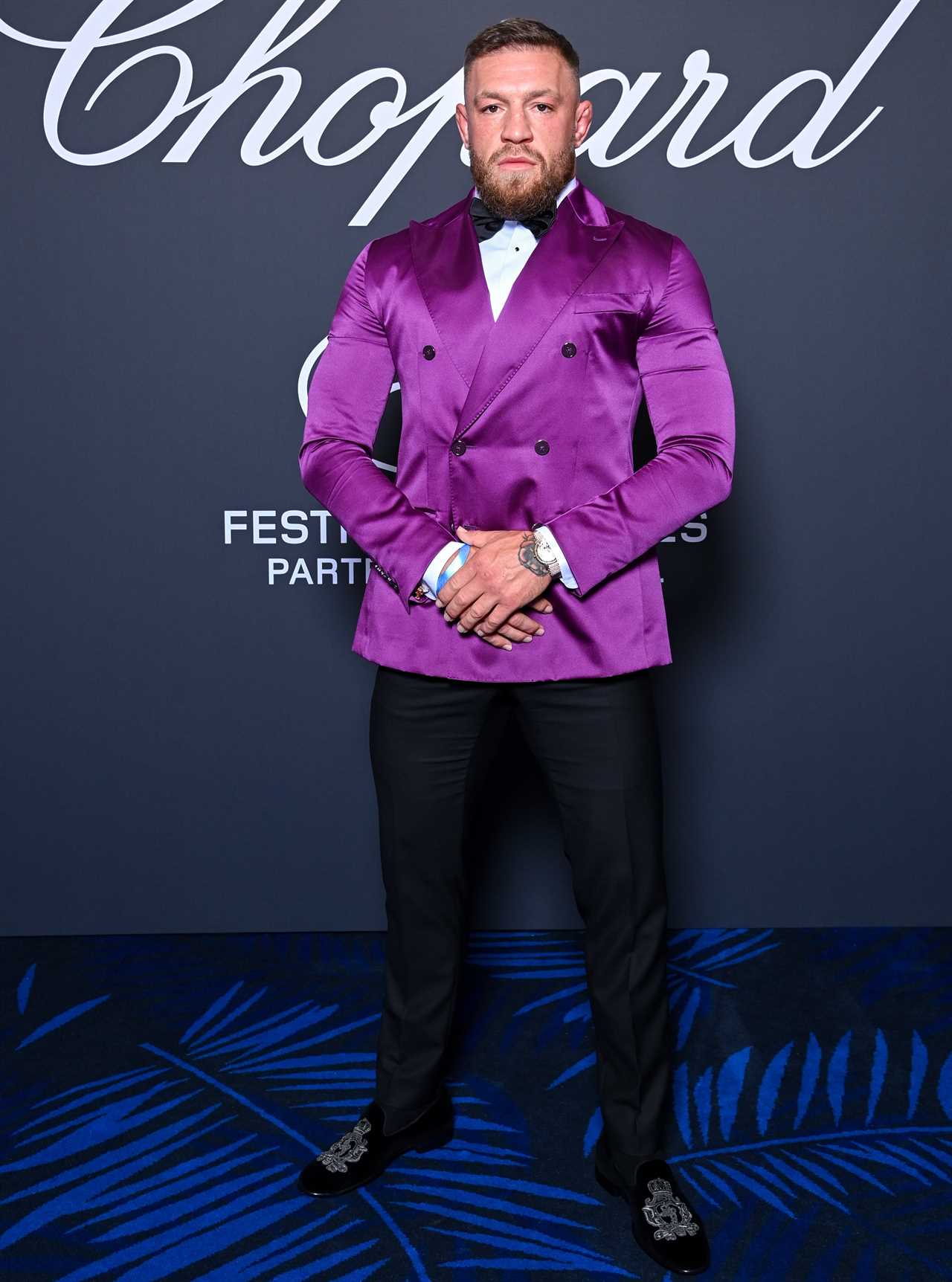 Conor McGregor, UFC star, looks enormous in a daring purple satin costume as he heads to Cannes Film Festival with Dee