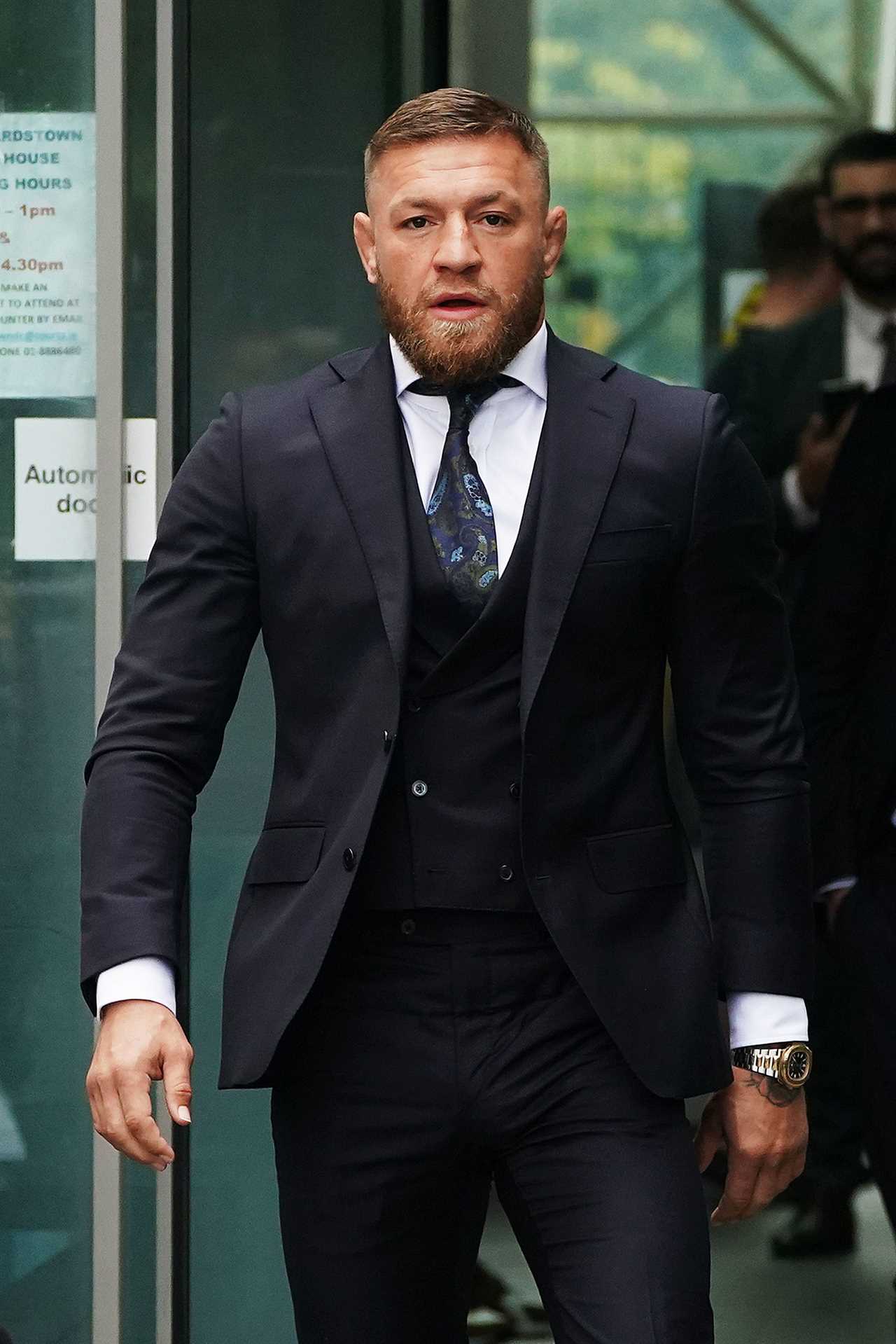 Conor McGregor, who is facing driving charges, compares himself with James Bond when he arrives in court wearing a three-piece suit.