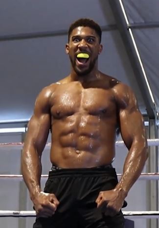 As Anthony Joshua, a henchman, performs a grueling wrist exercise to show off his incredible physique while training for the Usyk fight.