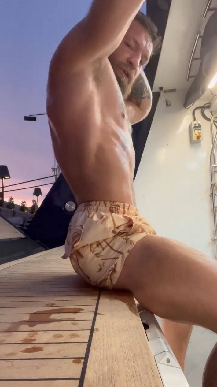 Conor McGregor, UFC fighter, shows off his ripped body after doing'spinal wave' exercises to give him a good workout.