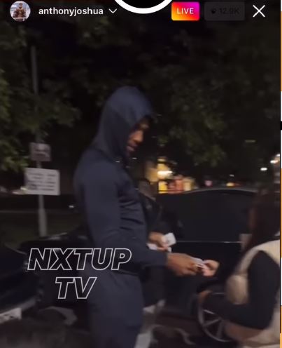 Anthony Joshua gives PS20 notes to shocked children in Watford, where he grew-up.