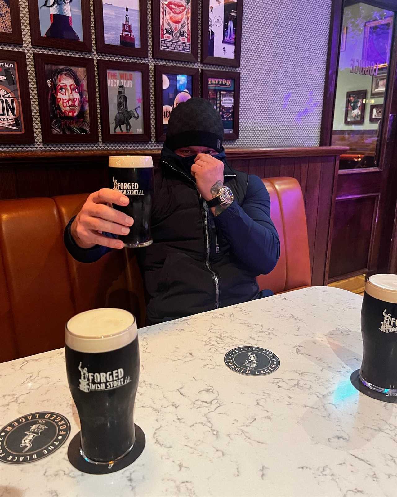 Conor McGregor covers his face with a pint, after being mocked for shaving his beard.