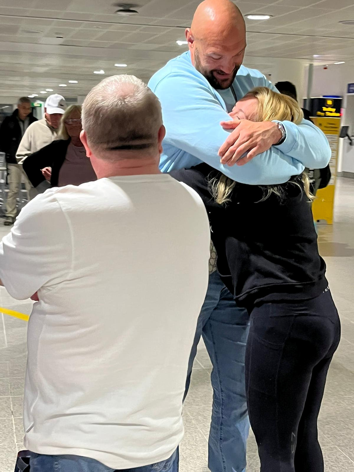 Tyson Fury embraces his wife Paris at the airport after he returns from Tenerife on a family holiday. He is preparing for Oleksandr Usyk's fight