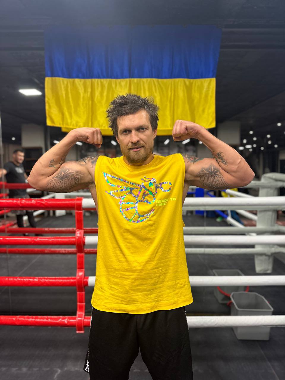 I'm here - Oleksandr Uzyk exaggerates his muscles while calling out Tyson Fury, who is posing in front the Ukraine flag