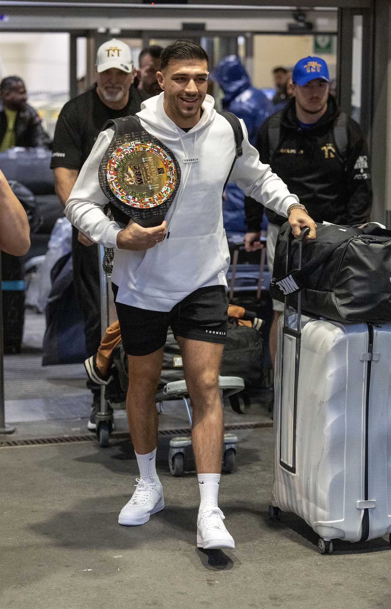 After a huge win over Jake Paul, Bruised Tommy Fury beams when he touches down at Heathrow together with dad John and brother Tyson.