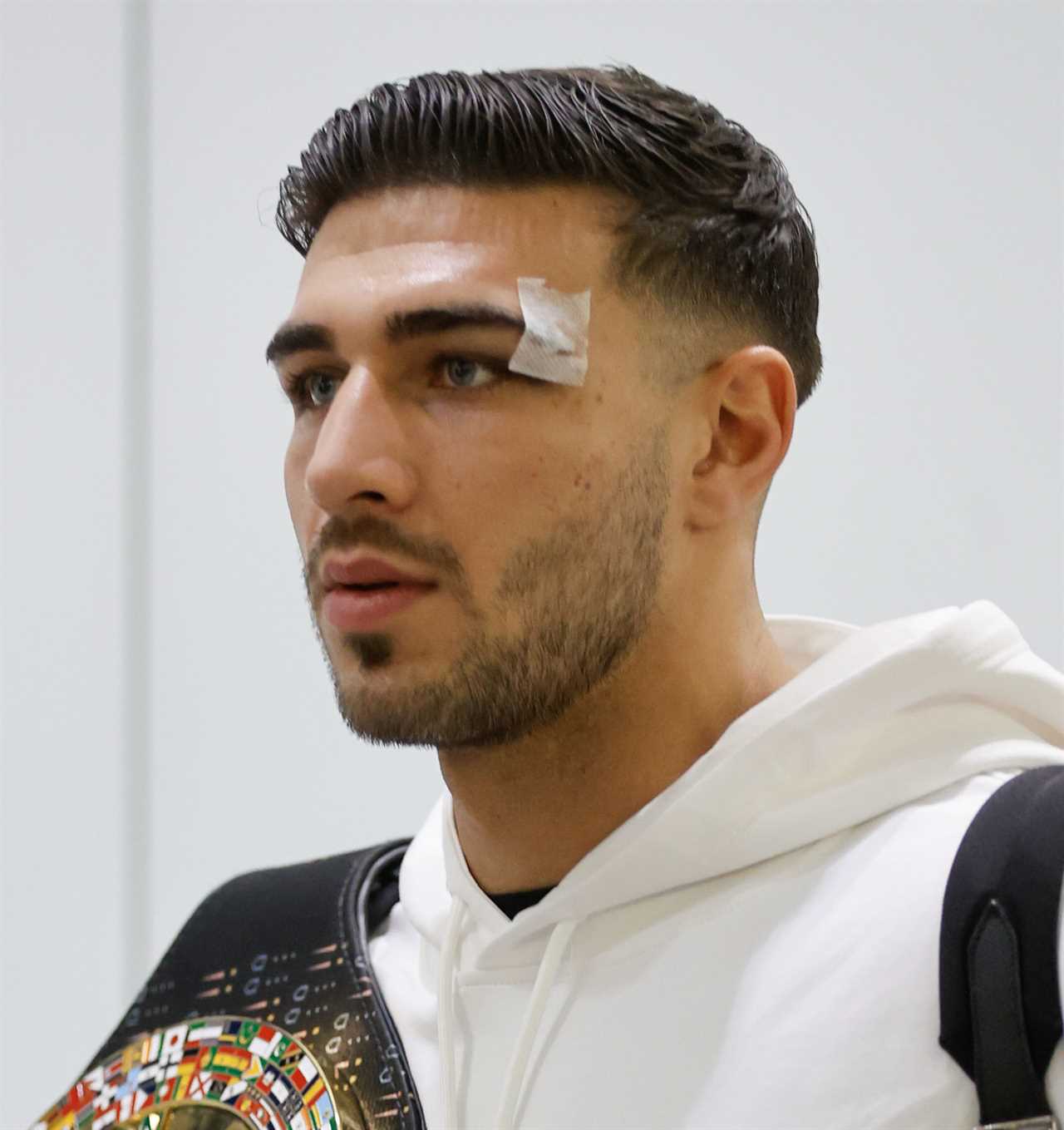 After a huge win over Jake Paul, Bruised Tommy Fury beams when he touches down at Heathrow together with dad John and brother Tyson.
