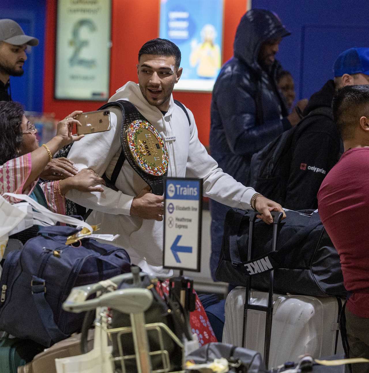 After a huge win over Jake Paul, Bruised Tommy Fury beams when he touches down at Heathrow together with dad John and brother Tyson.