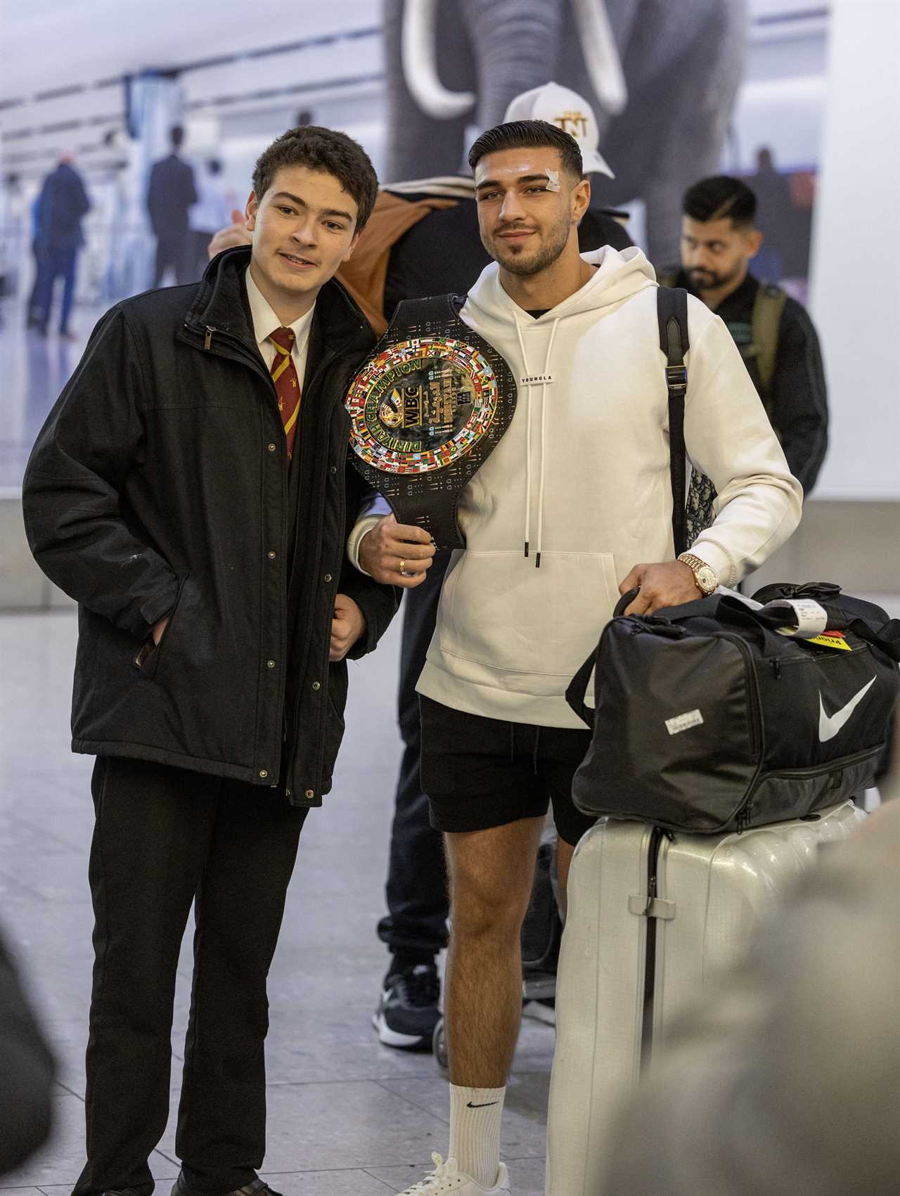 After a huge win over Jake Paul, Bruised Tommy Fury beams when he touches down at Heathrow together with dad John and brother Tyson.