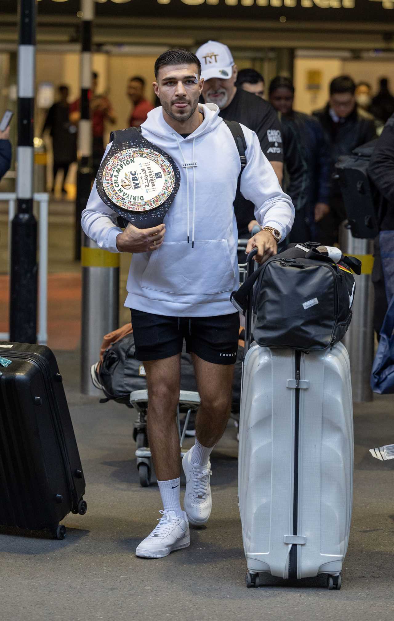 After a huge win over Jake Paul, Bruised Tommy Fury beams when he touches down at Heathrow together with dad John and brother Tyson.