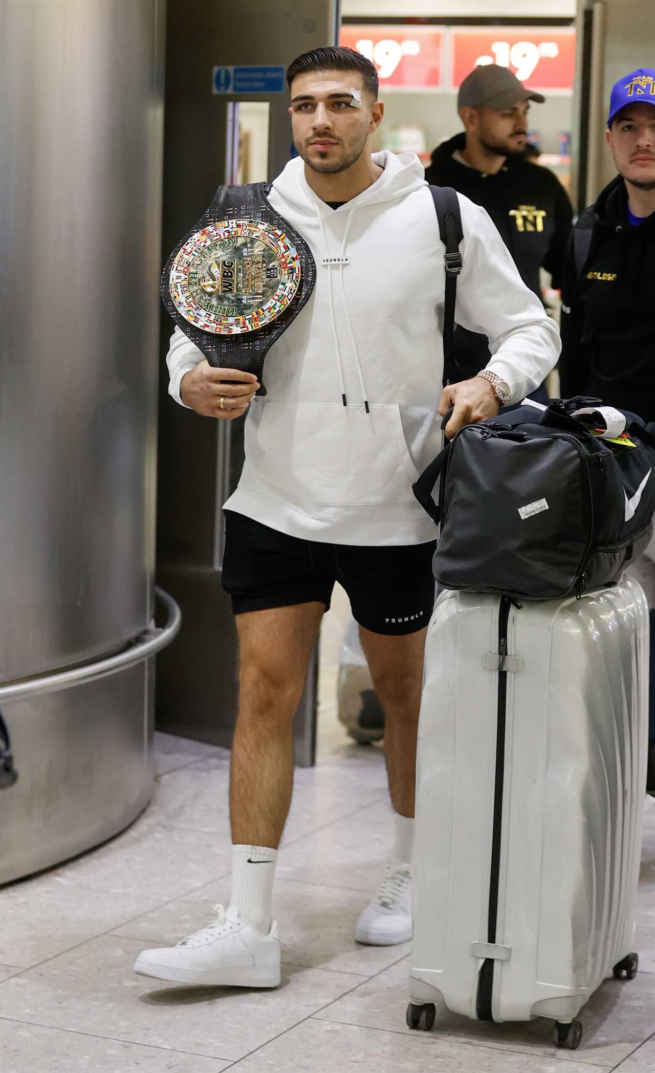 After a huge win over Jake Paul, Bruised Tommy Fury beams when he touches down at Heathrow together with dad John and brother Tyson.