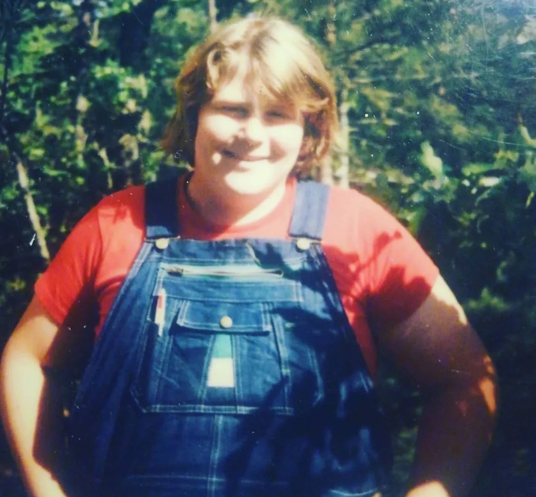 The boxing cult hero is unrecognizable in throwback snap, with long flowing hair and a cheeky smile while wearing dungarees