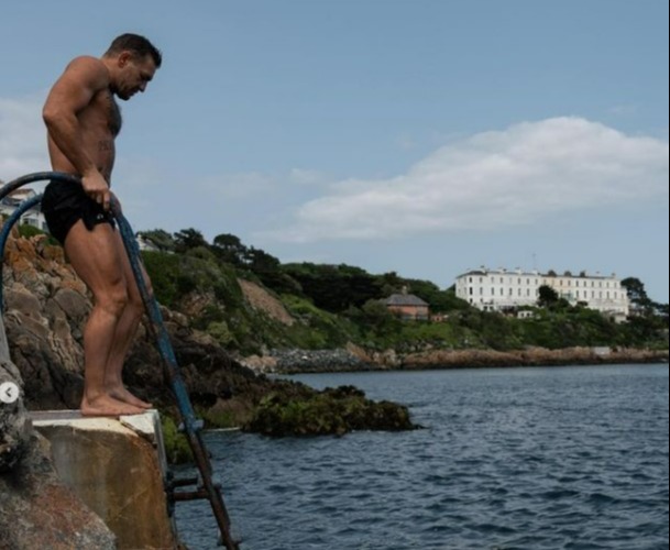 Conor McGregor gets back on his bicycle after he was hit by a car while cycling in Nigeria kit, then takes a dip in the ocean