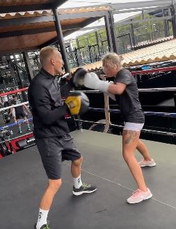 MMA and OnlyFans' star reveals that she is 'working hard, but playing even harder' before slamming trolls in a cheeky holiday message