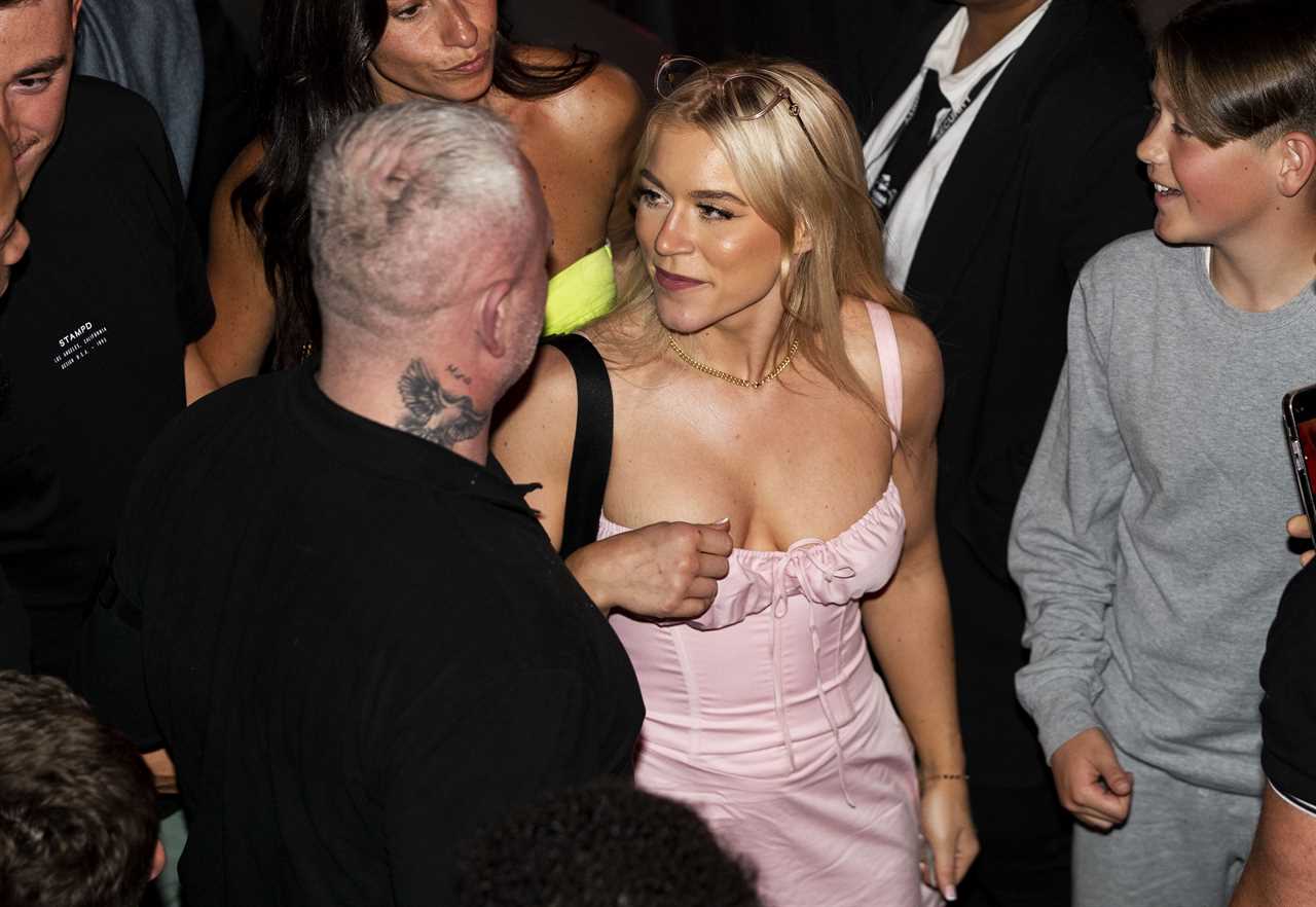Elle Brooke, a Man City fan and treble winner at the boxing match, watches on her phone as she watches the treble victory