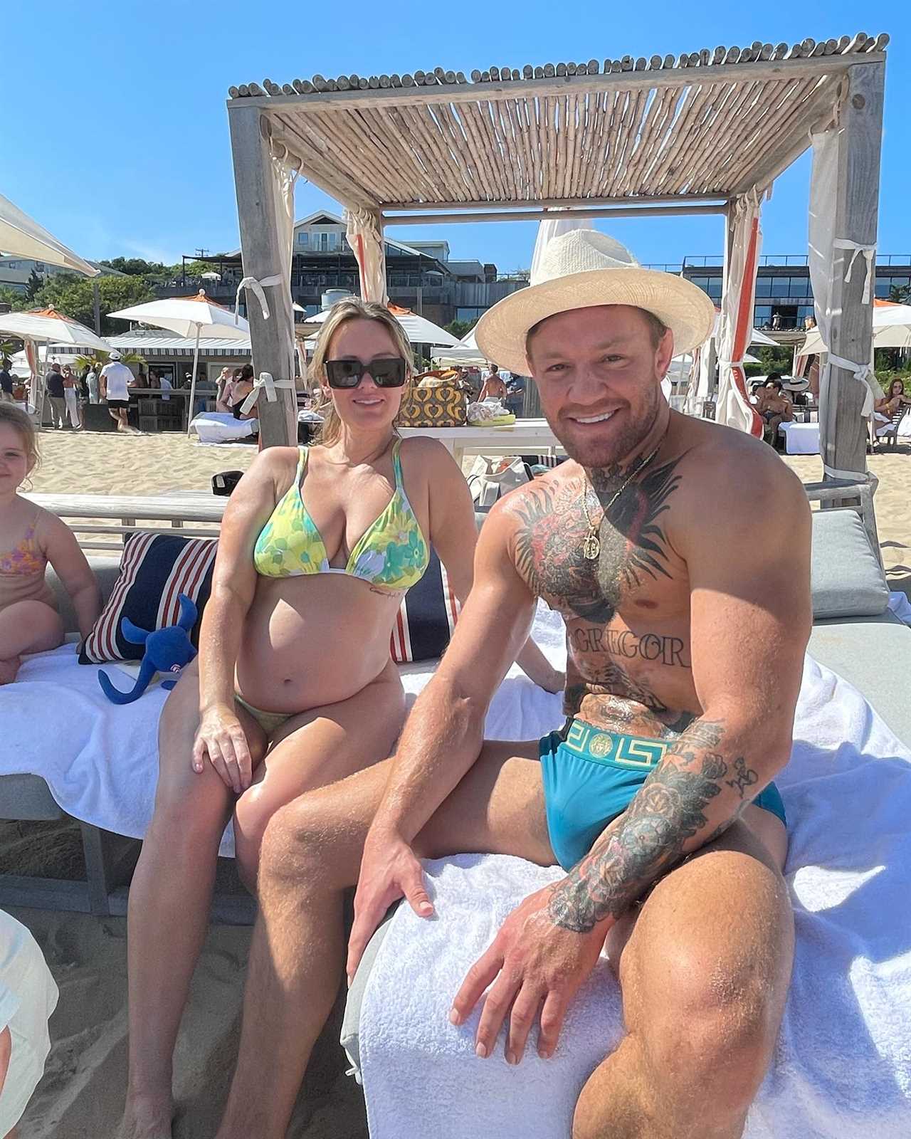 Conor McGregor stretches with his budgiesmugglers while UFC icon Dee Devlin, pregnant and her children hit the beach.
