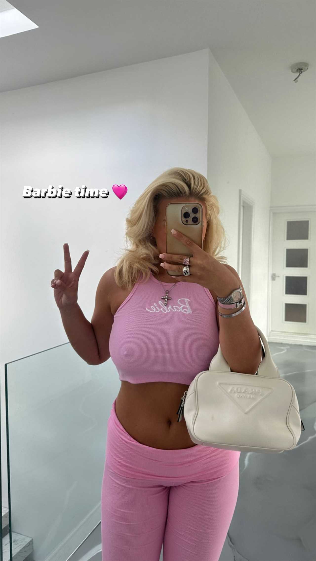 Watching Barbie, Apollonia Lewellyn, a busty ringgirl, suffers a wardrobe malfunction as her pink crop top is revealed.