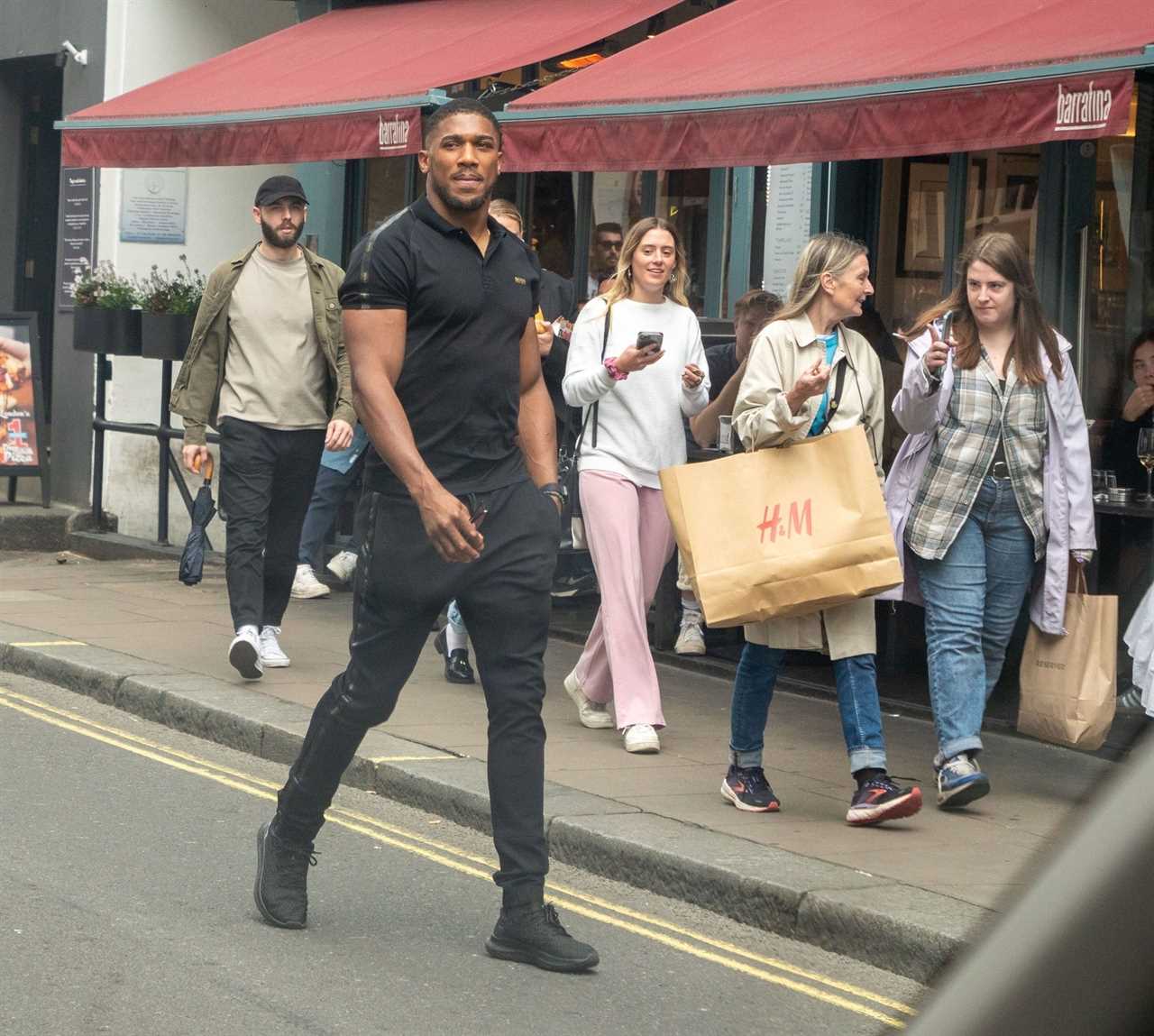 Anthony Joshua seen with a politics book while he meets his fans outside a restaurant