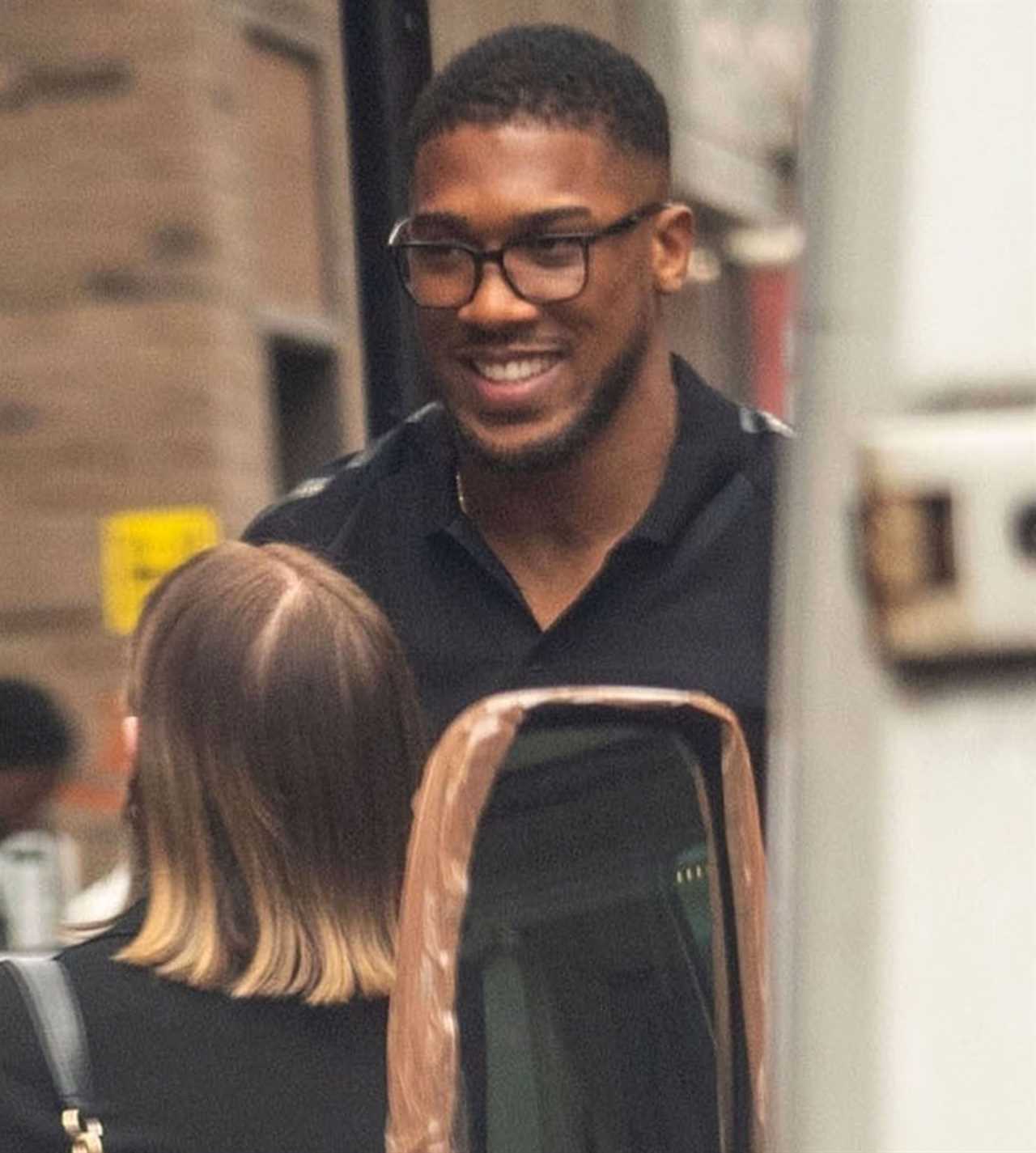 Anthony Joshua seen with a politics book while he meets his fans outside a restaurant